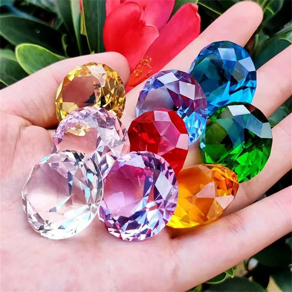 Hand holding a group of multi-colored crystal diamond-shaped paperweights