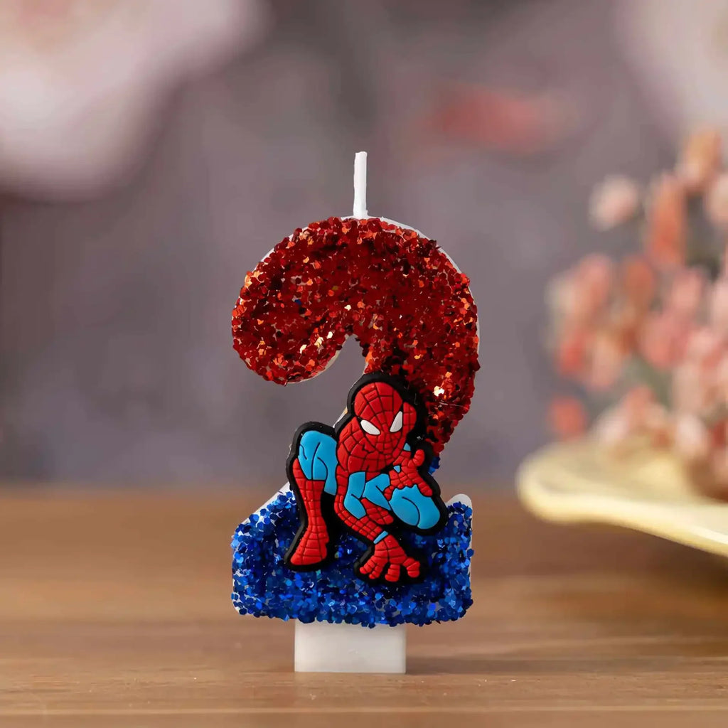 Number 2 birthday candle decorated with red and blue glitter and a cartoon superhero figure