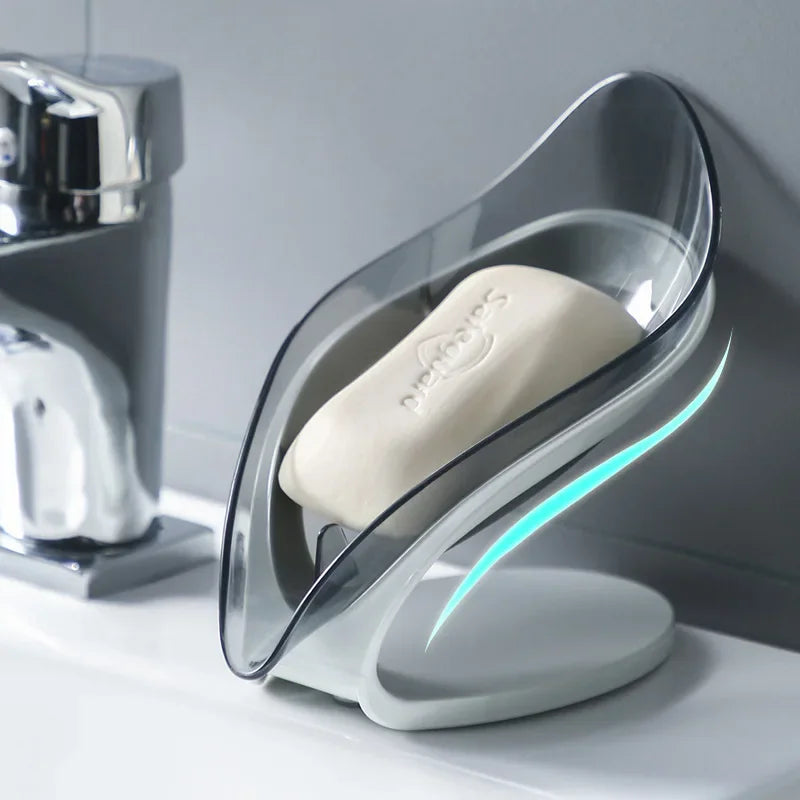 Leaf-shaped blue and grey plastic soap dish with a suction cup base