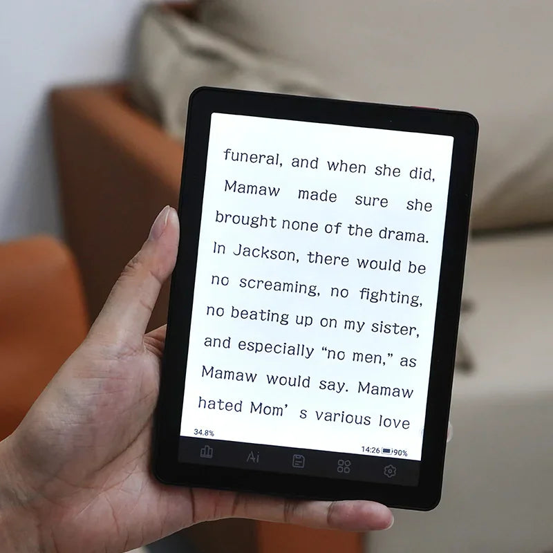 Hand holding an electronic reader displaying e-book text.