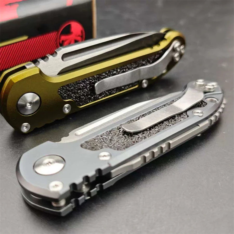 Two folding pocket knives with metal handles and textured grip inserts in grey and olive green.