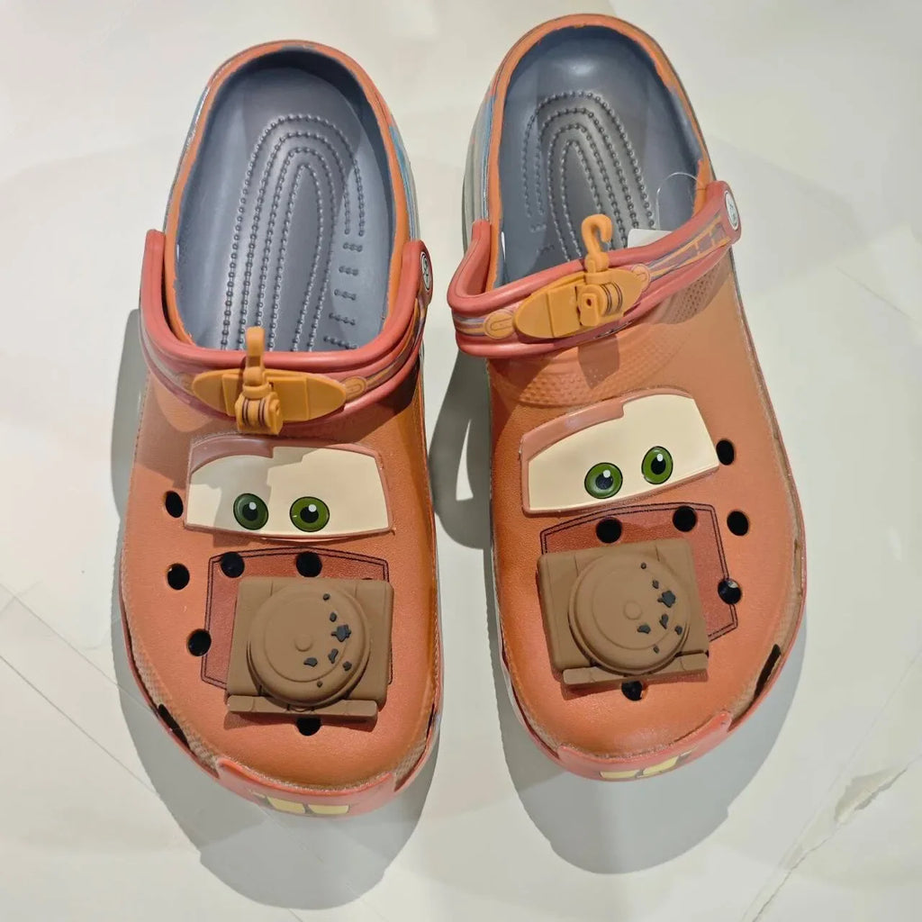 Top down view of brown cartoon tow truck themed clogs showing interior footbed and engine charms.