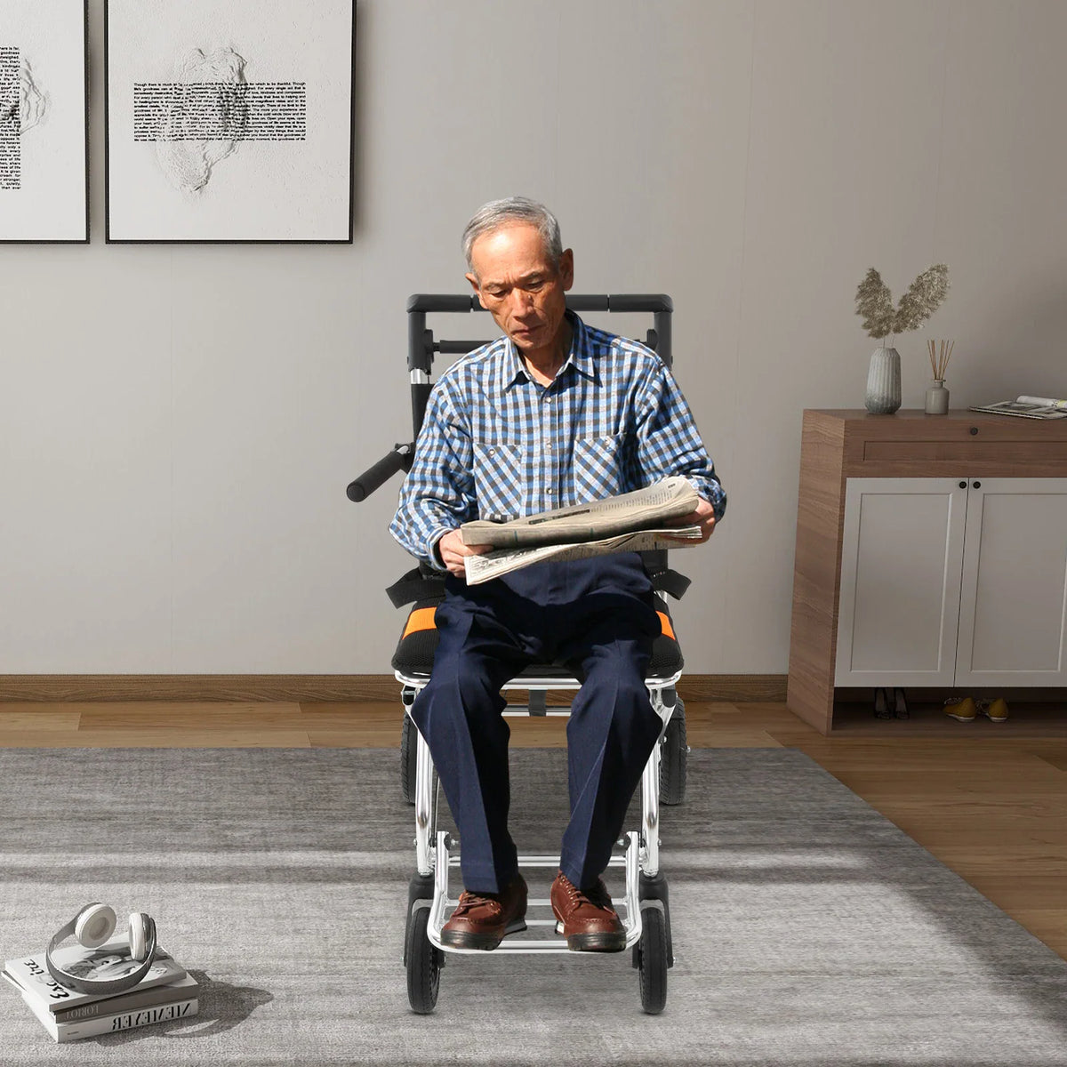 Senior man sitting on a portable wheelchair indoors reading a newspaper