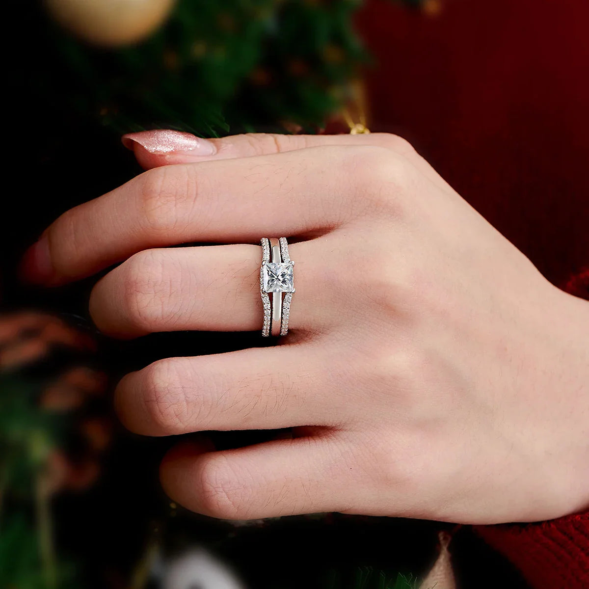 Sterling silver princess cut engagement ring set worn on a finger.