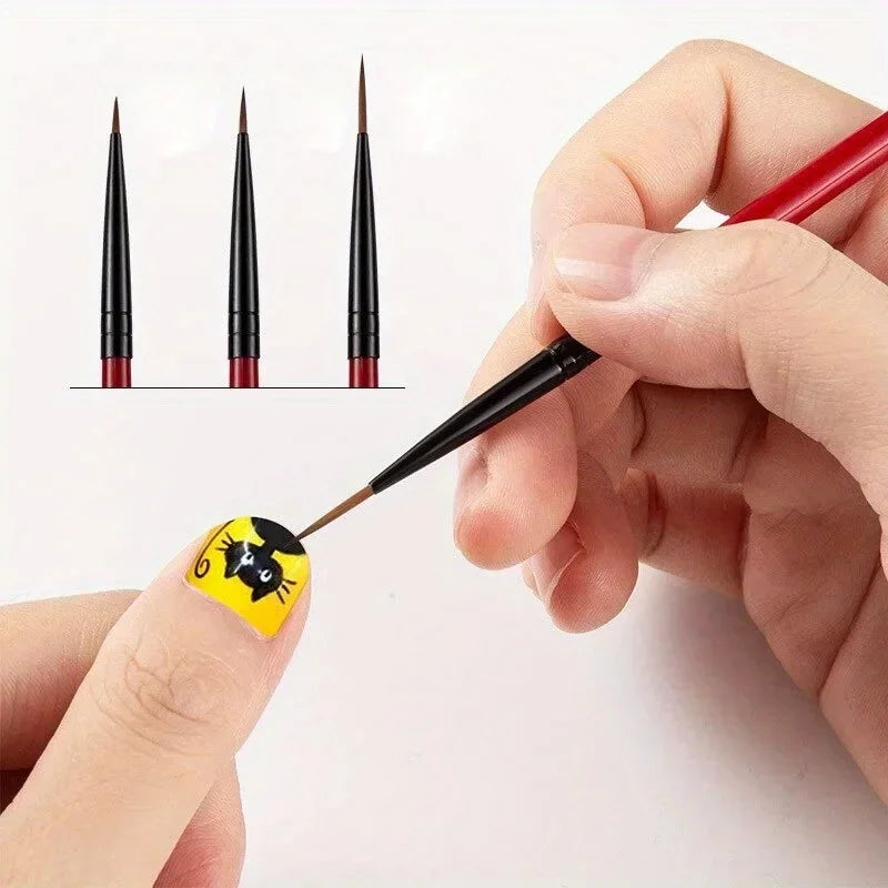 A hand using a thin nail art liner brush to paint a cat design on a fingernail