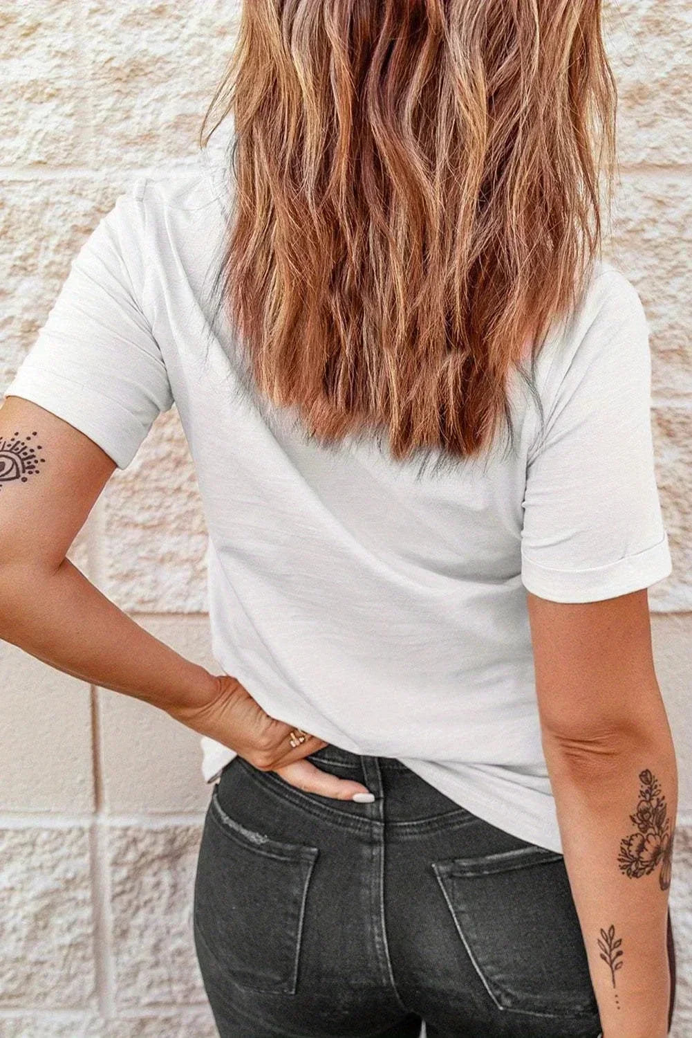 Person wearing a plain white t-shirt and dark jeans from behind