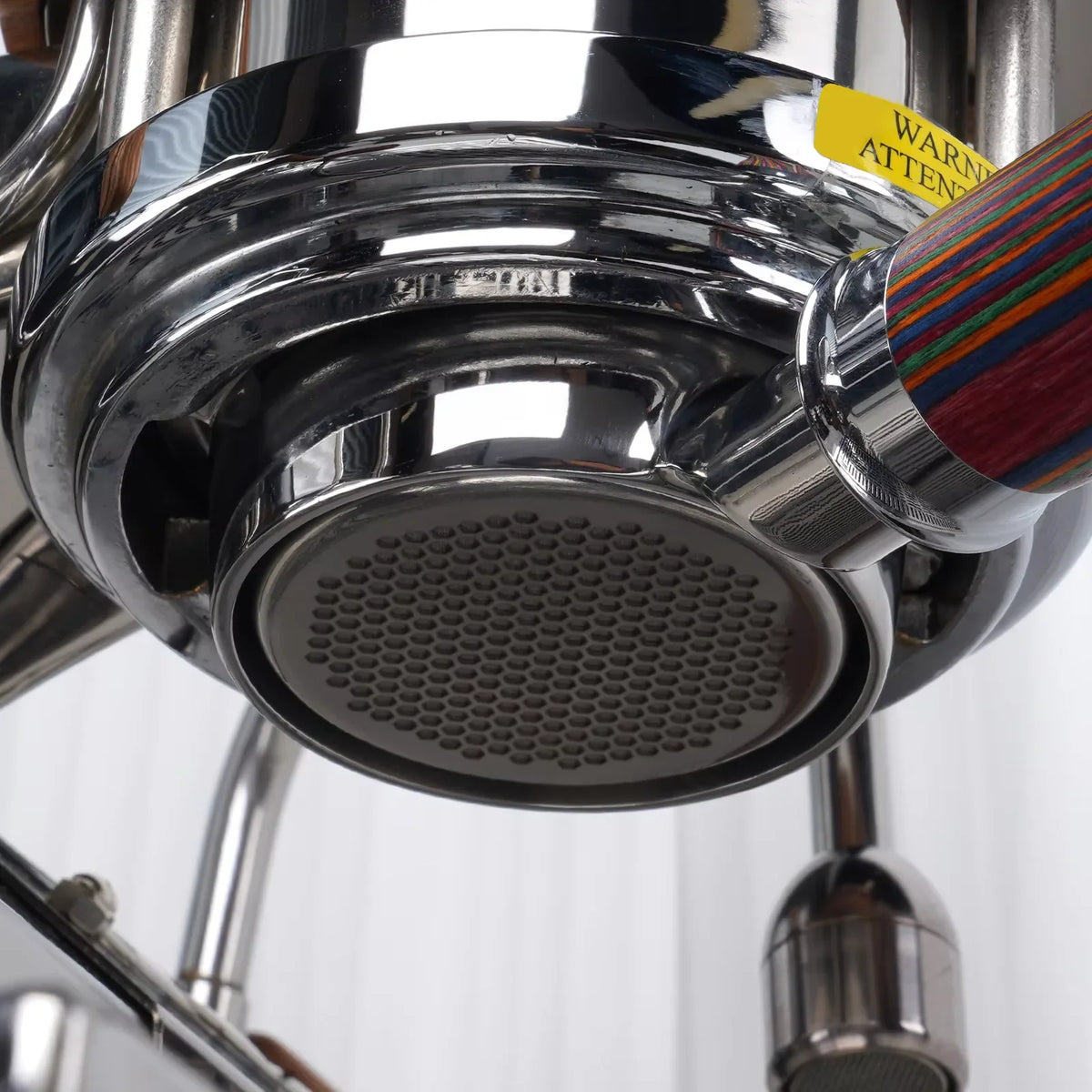 Underside view of an espresso machine group head with a beehive filter screen