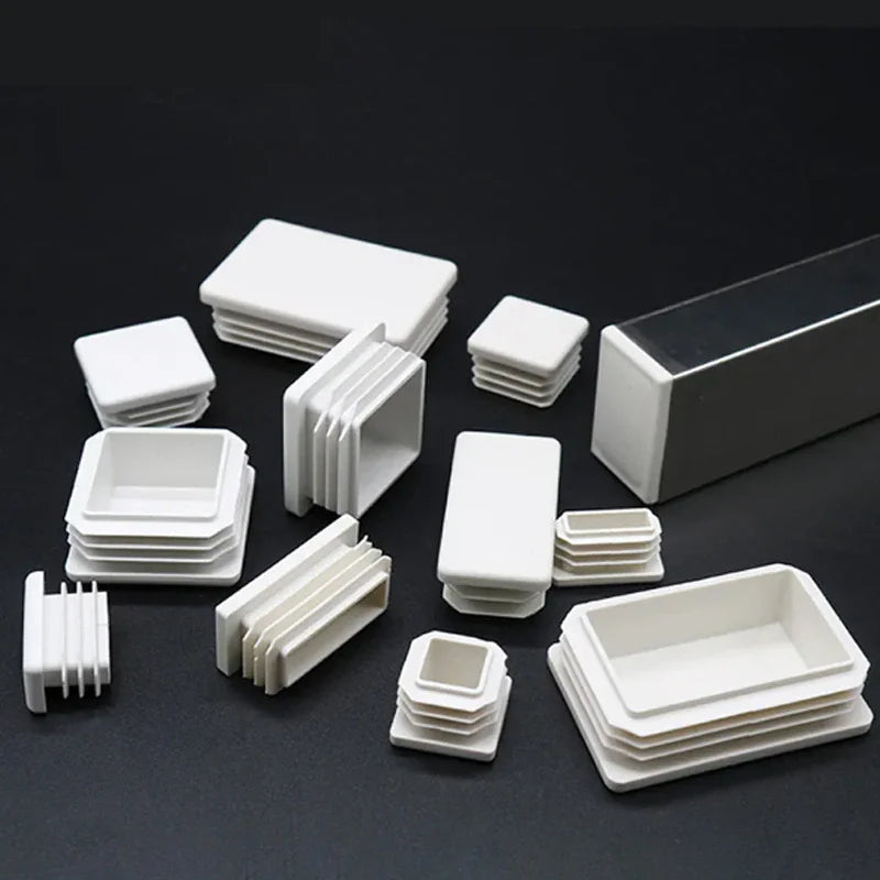 Assorted white plastic square and rectangular tube end caps and one installed on a metal tube