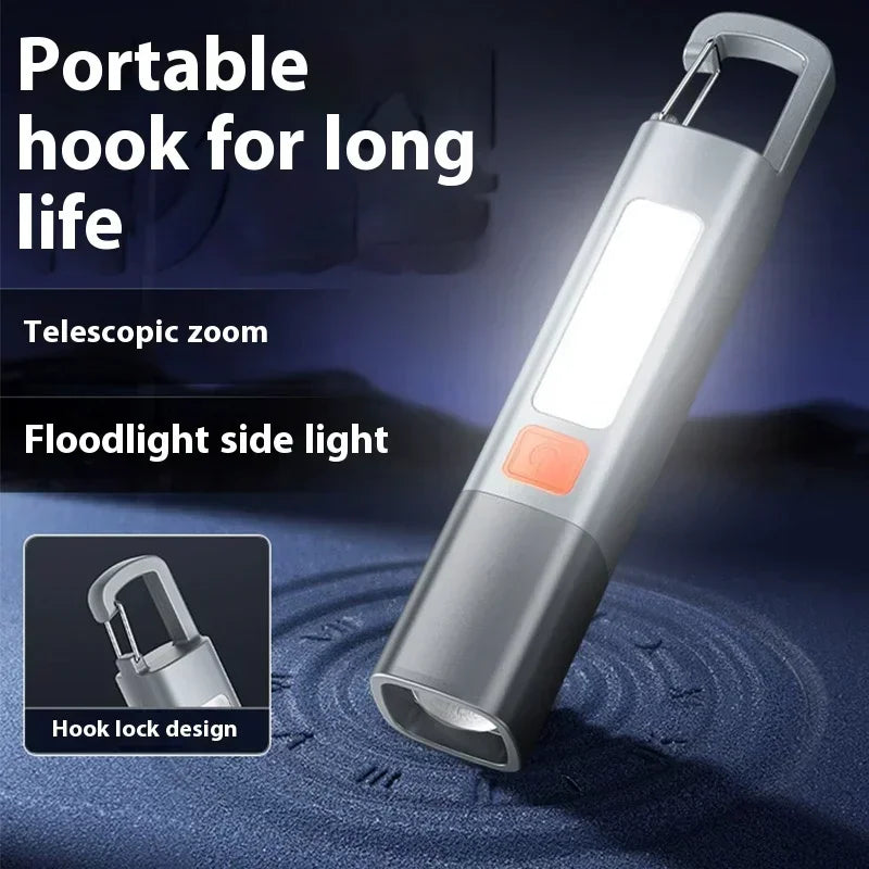 Grey handheld LED flashlight with a carabiner clip and COB side light feature