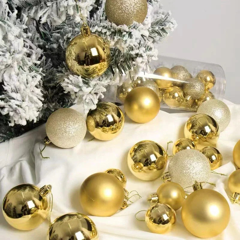 Gold Christmas baubles displayed on a white cloth with a snowy pine branch background