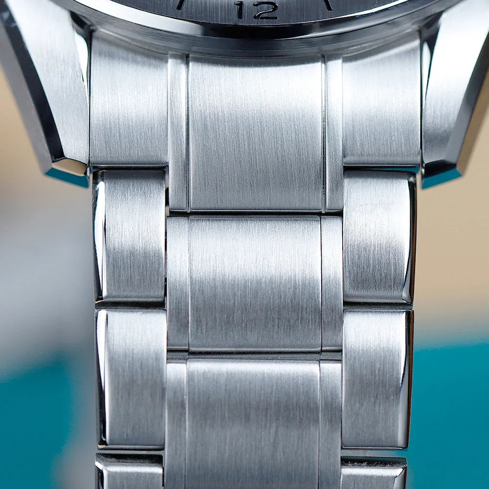 A macro shot focusing on the brushed stainless steel links of a watch bracelet.